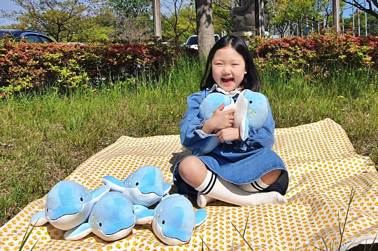 우시산의 상괭이 인형을 안고 좋아하는 아이의 모습. <SK이노베이션 제공>
